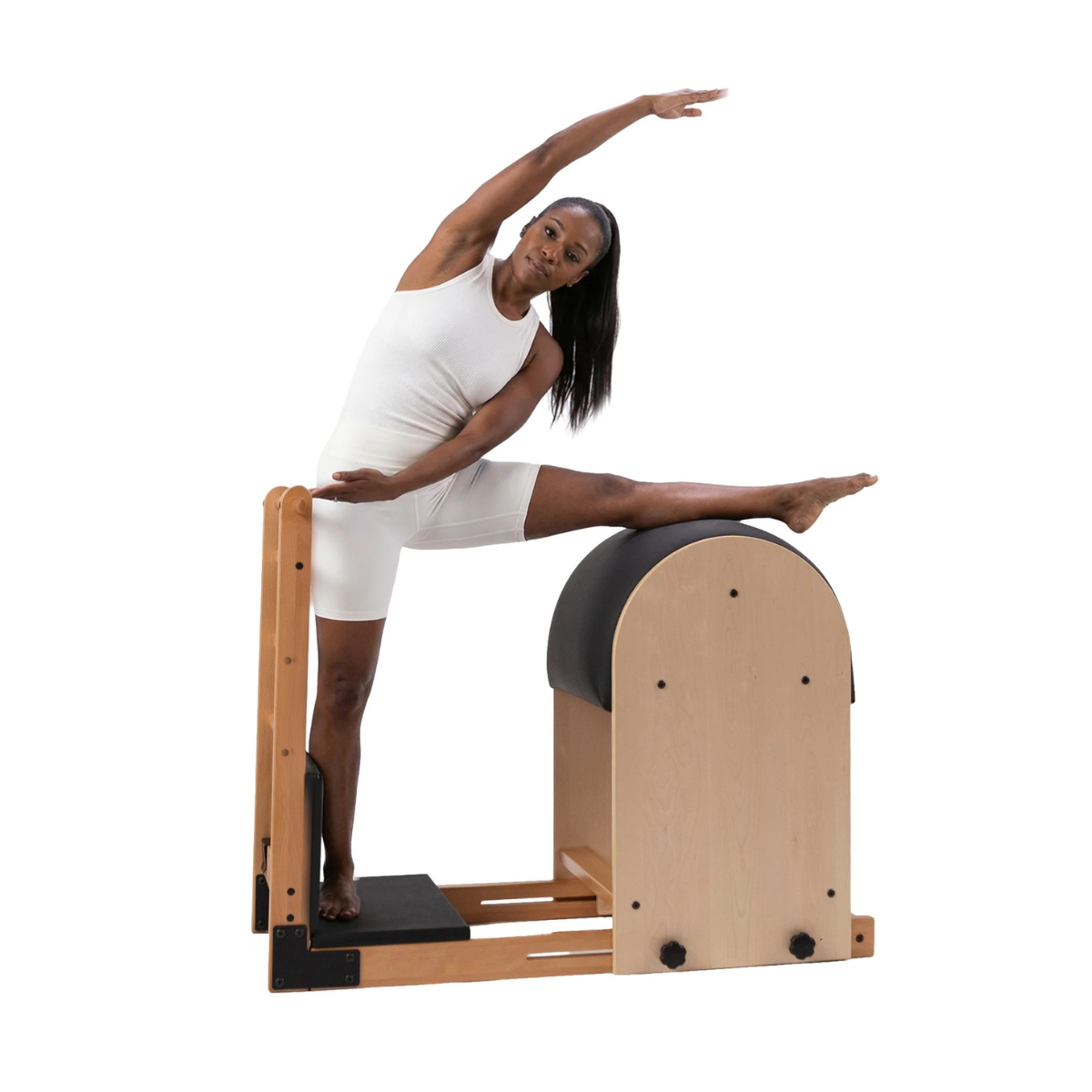 Vrouw doet een side stretch op de Artistry High Ladder Barrel van Peak Pilates