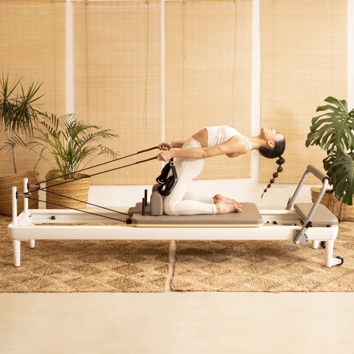 Vrouw traint met armveren op de Nubium Reformer van Elina Pilates